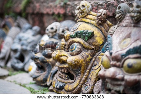Souvenir masks near wall on Nepalese street market, Kathmandu, Nepal.
