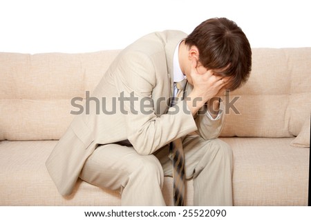 stock-photo-a-disappointed-businessman-holds-hands-on-his-face-sitting-on-sofa-25522090.jpg