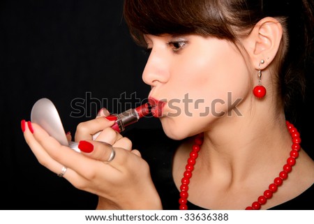 stock photo Beautiful young woman painting lips in red color