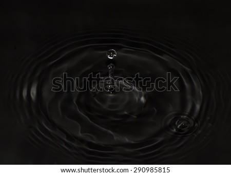 Drop of water falling on black water
