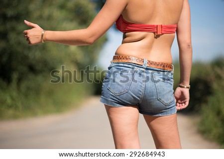 Hitchhiking girl in bikini on a sunny day