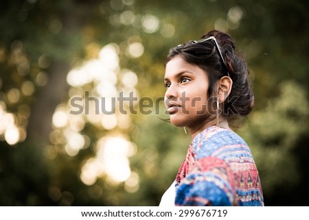 Young beautiful indian girl in nature with impressive bokeh background