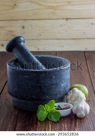 Garlic bulbs and cloves with stone Pestle and mortar on a wooden table