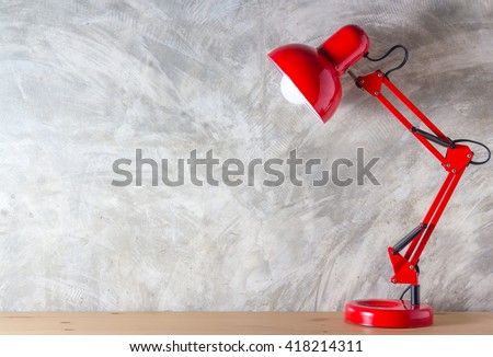 Red lamp on wooden desk in modern room, with copy space.