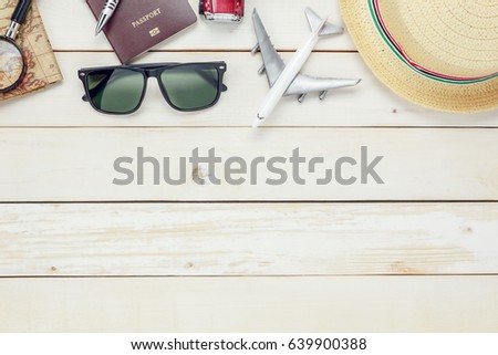 Top view essential travel items. map, passport, airplane, eyeglasses on white wooden background.