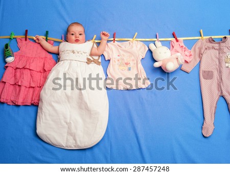 Baby in a sleeping bag is hanging on a rope