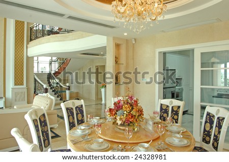 this is the dining room,  a few dining chair around a table,there is a bottle of flowers on the table.