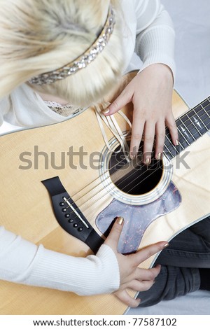 Female guitar player on white background