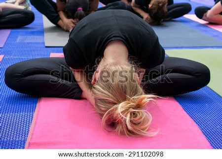 Woman at yoga head leaning forward on the mat