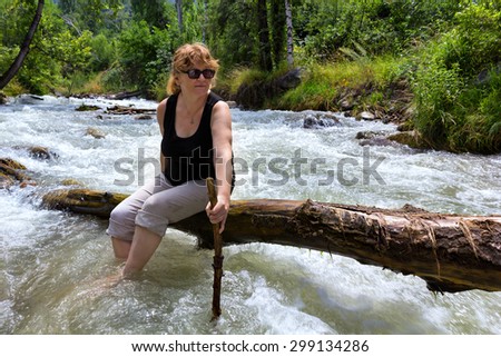 A woman goes on a log mountain river