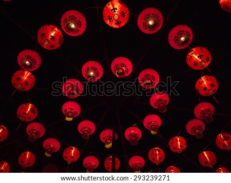 The multi circle form layer of light-up red Chinese style  paper lantern at night with dark black sky as background. There are two similar images, one wide angle shot and the other close up shot.