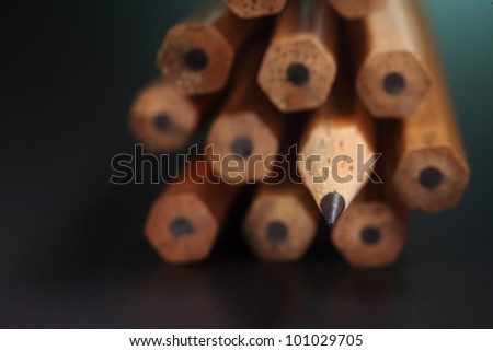 One sharpened pencils in row with pencil ends,