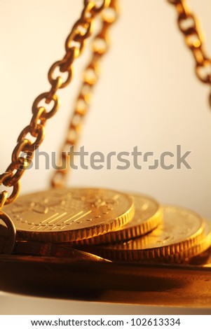 stacks of bright new shiny gold coins placed on weighing scales