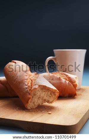 baguette on chopping board and coffee cup