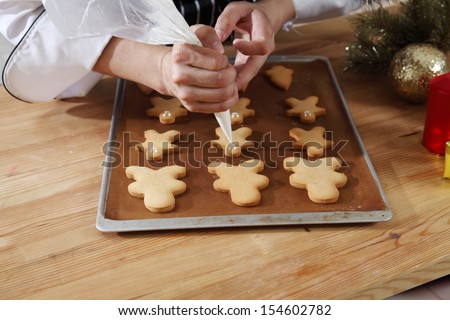 close up of the chef decorating cookies with icing sugar