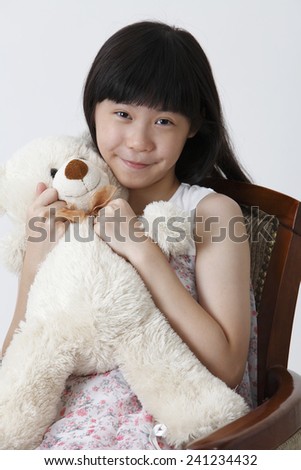 girl hugging a soft toy teddy bear