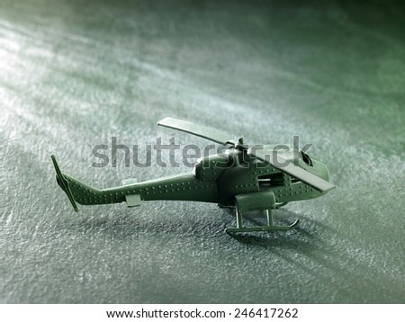 green plastic toy helicopter on the green background
