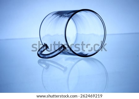 glass cup laid down on top of glass table