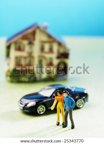 miniature couple in front of car and house