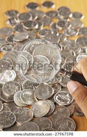 coins under magnifying glass, close-up