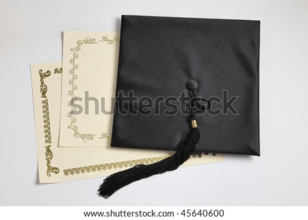 Graduation cap and diploma on the plain background