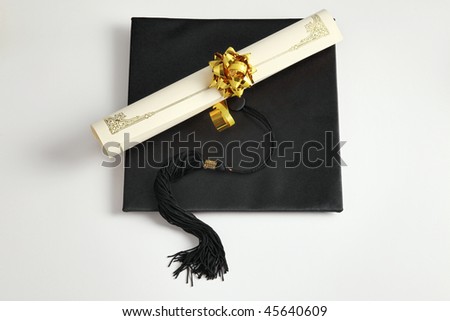 Graduation cap and diploma on the plain background