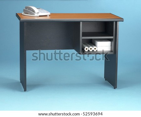 Office table with a telephone on it on blue background.