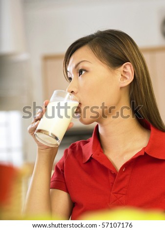 woman drinking milk in kitchen