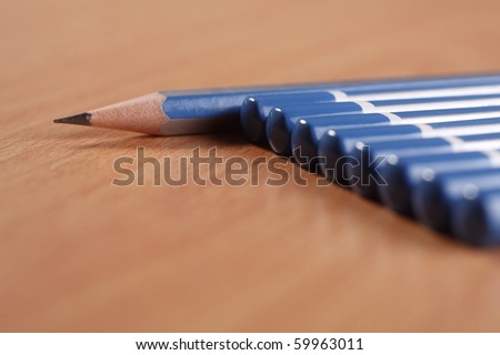 A sharpened pencil among a row of blunt end pencils