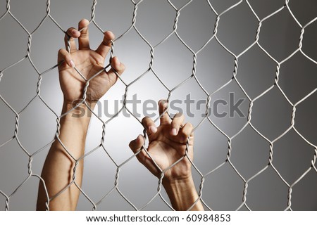 depression - close up of hand on chain-link fence.