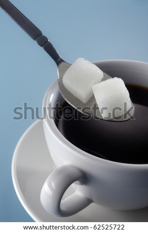 stock image of adding sugar to coffee