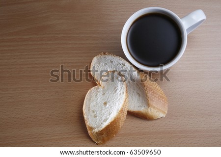 Coffee and two slices of baguette on the table top.
