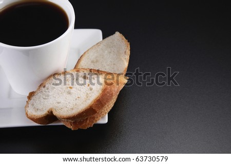 Coffee and two slices of french loaf on the table top.