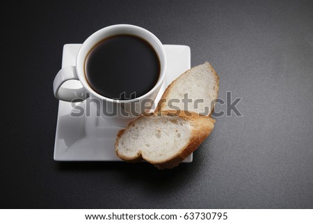 Coffee and two slices of french loaf on the table top.