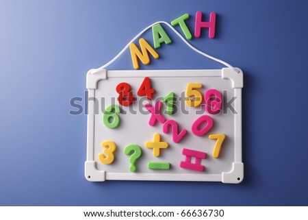 Whiteboard with magnetic numbers and letters isolated on the blue background.