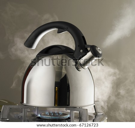 Close up shot of steaming tea kettle. Heater glow under the kettle.