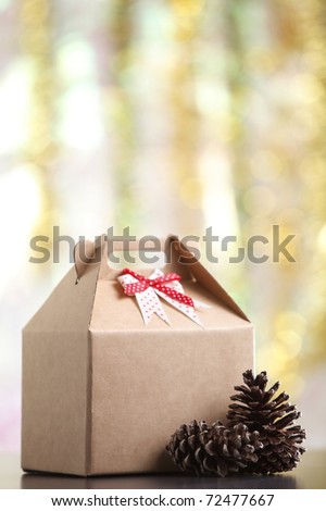 Cardboard box with pine cones next to it.