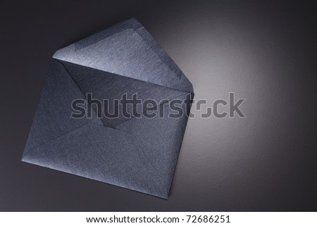 Black envelope isolated on the black background.