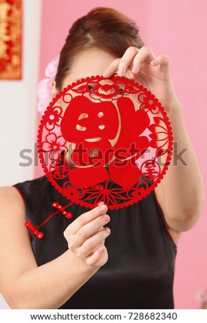 Young woman holding paper cutting face hidden