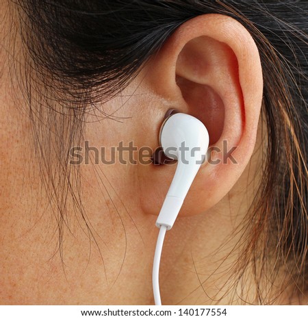 White Earphone in a Girl\'s Ear
