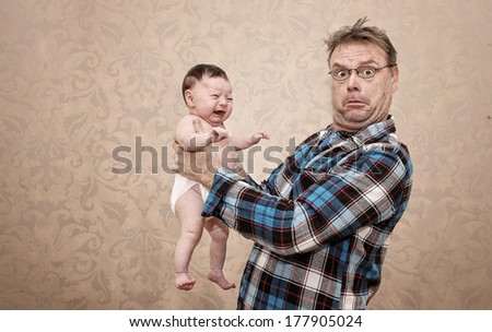 Father Holding his Young Baby with a Surprised and Confused Expression