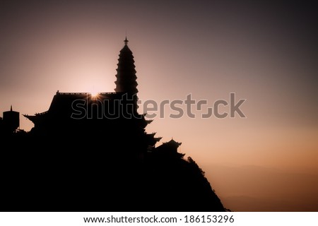 Ji Zu Shan Temple (Chicken's Foot Mountain Temple) Silhouetted against the Early Morning Sunrise. An active Buddhist temple in Yunnan province, China.