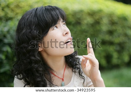 Chinese woman looking and pointing upwards