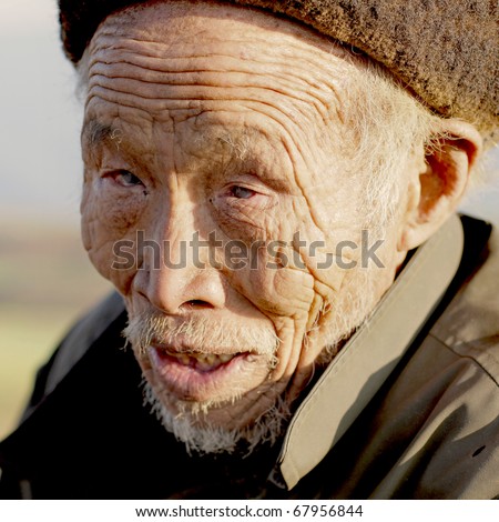 DONGCHUAN CHINA - NOVEMBER 23: Old blind Chinese man begging for money, November 23, 2010 in Dongchuan, China. China is estimated to account for over 18% of the world\'s blind population.