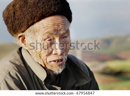 DONGCHUAN CHINA - NOVEMBER 23: Old blind Chinese man begging for money, November 23, 2010 in Dongchuan, China. China is estimated to account for over 18% of the world\'s blind population.