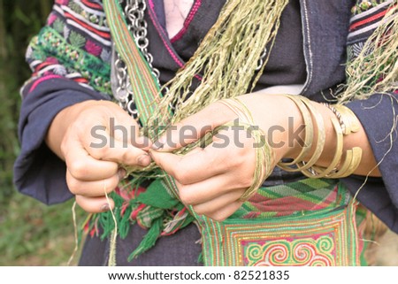 SAPA VIETNAM - AUGUST 6: Woman of Black Hmong ethnic minority weaving hemp fibers, on august 6, 2011, in Sapa, Vietnam. Hemp is the traditional form of cloth among the minority cultures of this region