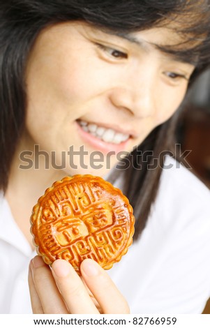 Moon cakes- Narrow focus picture of a beautiful Asian girl eating a moon cake, the traditional food of the Chinese mid-Autumn festival