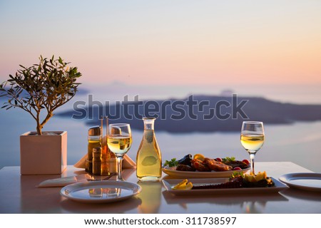 Romantic dinner for two at sunset.Greece, Santorini, restaurant on the beach, above the volcano.