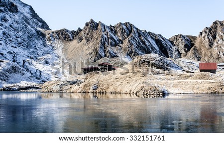 Mountain landscape with lake and cabin
