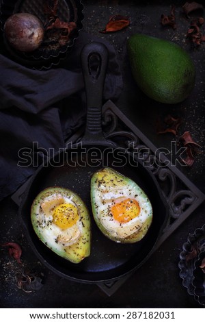 baked avocado with egg on a dark background
